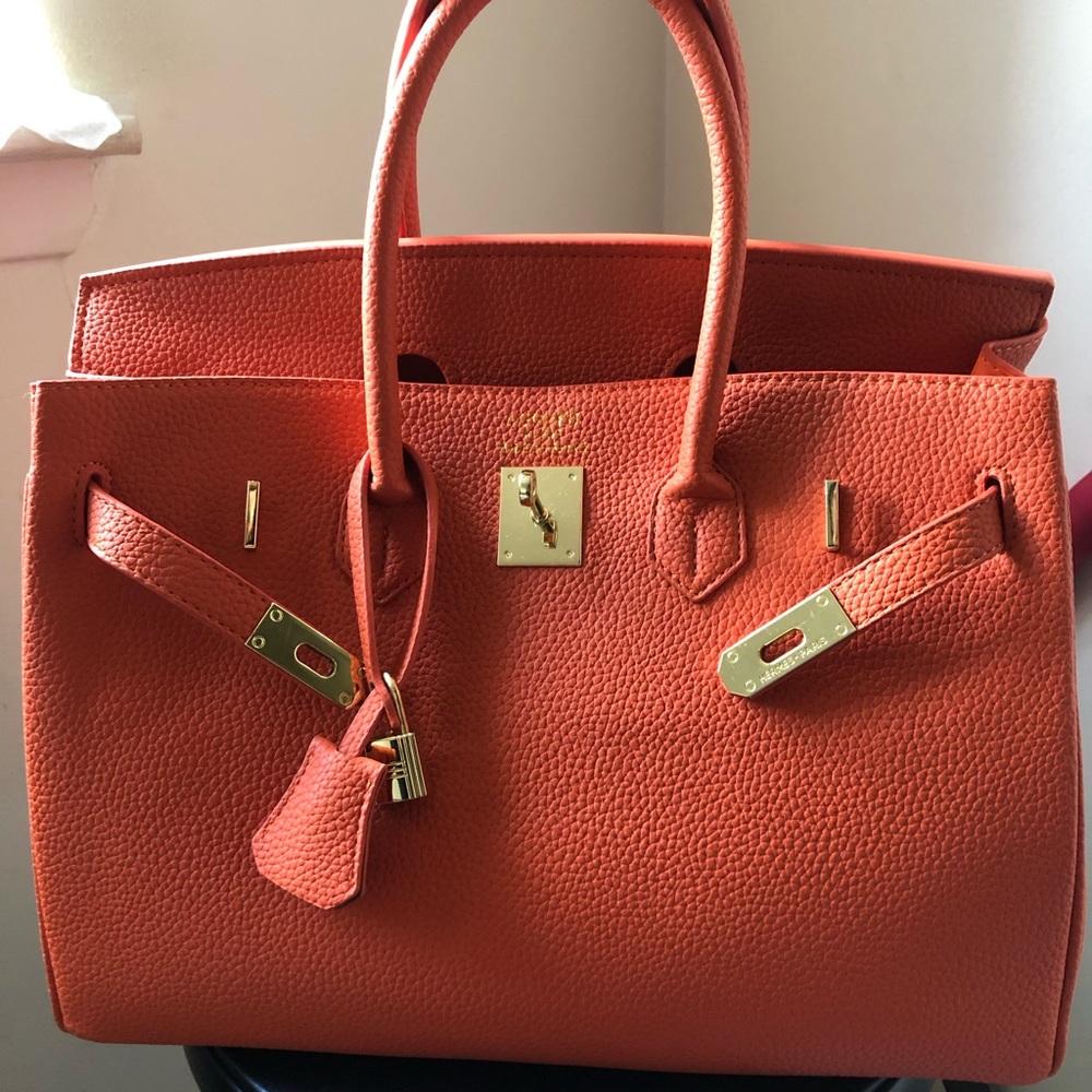 Replic handbag orange size 35. Has logo and the logo is little larger